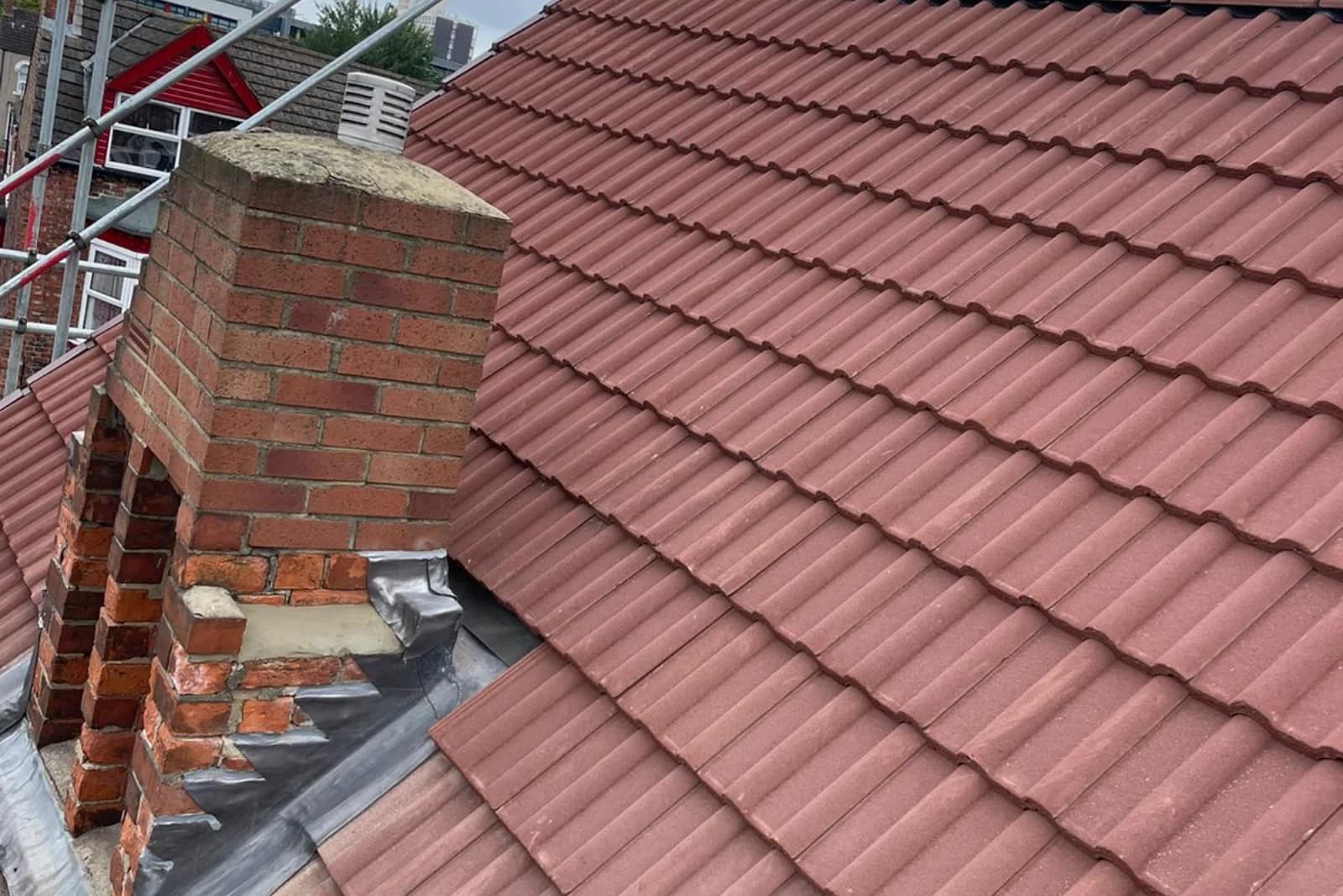 Tiled roof with a rebuilt chimney and new lead flashing on an urban property in the North East